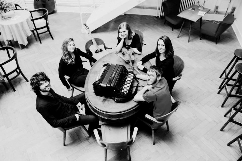Triunfal Quintet gezeten rond een tafel