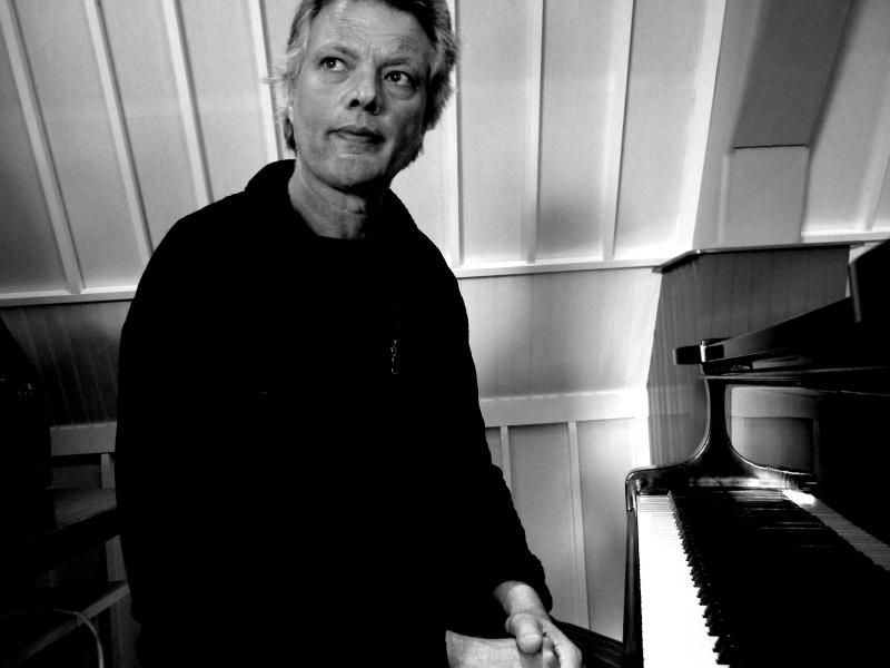 Walter Lampe poseert naast piano
